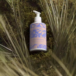 Flacon de face de l’après-shampoing hydratant "Sublime Soie Végétale" de Rose et Jules, bio, vegan et naturel, mis en valeur en studio parmi des végétaux et de la mousse.